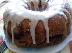 a bundt cake sitting on top of a plate covered in icing and drizzle