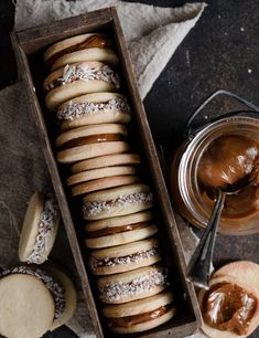 a wooden box filled with cookies next to a jar of peanut butter