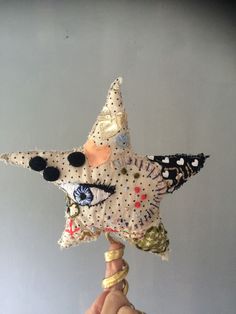 a hand holding up a decorative star ornament