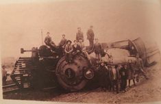 an old black and white photo shows men standing on top of a train engine, with one man in the foreground