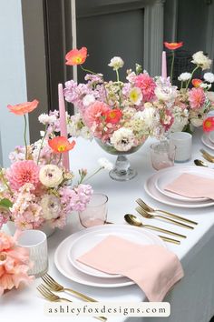 the table is set with pink and white flowers in vases, silverware, and plates