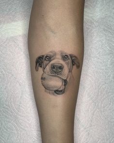 a dog with a bone in its mouth tattoo on the left calf's leg