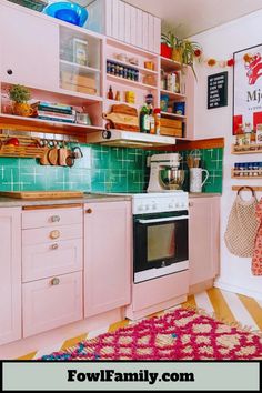 a kitchen with pink cabinets and green tile backsplash, white appliances and wooden shelves