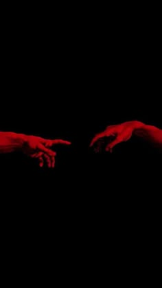 two hands reaching out towards each other in the dark, with red paint on them