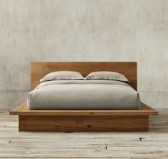 a bed sitting on top of a wooden platform next to a white wall and floor