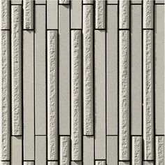 a close up view of a wall made out of white bricks and concrete blocks with vertical lines on each side