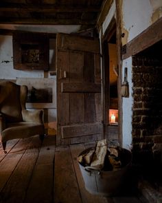 an old chair sitting in the middle of a room next to a fireplace and door