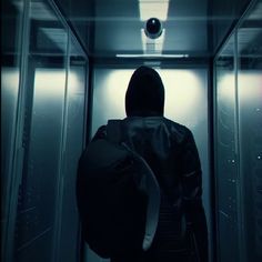 a person in a dark room with a backpack