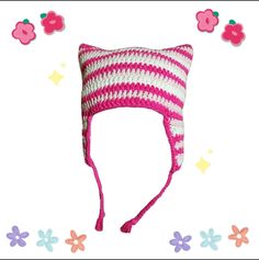 a crocheted hat with pink and white stripes on the side, surrounded by flowers