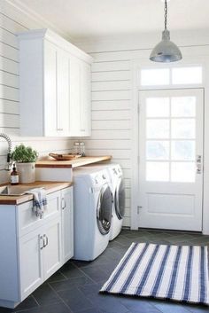 a washer and dryer in a white laundry room with blue tile flooring