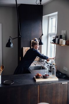 a woman standing at a kitchen counter preparing food