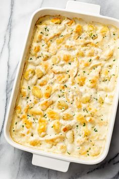 a casserole dish with chicken and cheese in it on a marble countertop