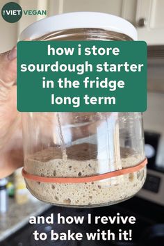 someone is holding up a jar with food in it that says, how i store sourdough starter in the fridge long term and how i revive to bake with it