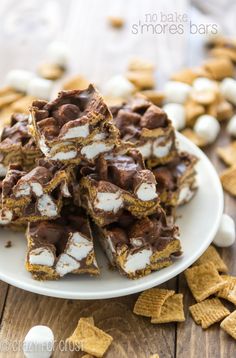 chocolate marshmallow s'mores bars on a white plate with graham crackers