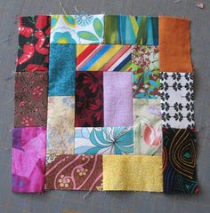 a patchwork quilt is laying on the ground with many different colors and patterns in it