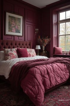 a bedroom with red walls and purple bedding, pillows and blankets on the bed