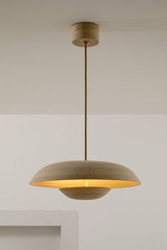 a light fixture hanging from the ceiling in a room with white walls and flooring