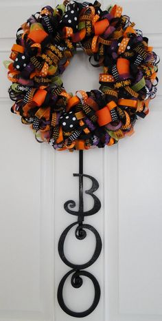 a halloween wreath hanging on the side of a door