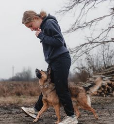 a woman is walking her dog in the dirt