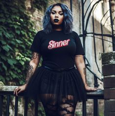 "Indulge in the wickedly delightful irony with our \"Sinner\" vintage devilish tee. Picture this: a Barbie doll, the epitome of innocence, reimagined with a devilish twist. It's a playful and humorous contrast that adds a touch of rebellious charm to your wardrobe. Crafted with a rebellious spirit and a nod to vintage aesthetics, this shirt isn't just about making a statement; it's about rewriting the rules of fashion. The comfortable Airlume combed and ringspun cotton ensures a soft touch against your skin, providing both comfort and style in one devilishly delightful package. Embrace the darker elements with a tee that exudes confidence and attitude. The unisex fit guarantees a versatile wardrobe piece that anyone can rock with flair. Make a bold statement that echoes your rebellious spi Edgy Black T-shirt For Party, Fitted Punk Style Party T-shirt, Grunge Halloween Party Tops, Black Fairy Grunge Top For Party, Black Fairy Grunge Party Top, Fairy Grunge Fitted Short Sleeve T-shirt, Fitted Grunge T-shirt For Night Out, Gothic Fitted T-shirt For Streetwear, Fitted Crew Neck Fairy Grunge T-shirt