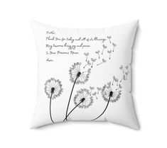 a white pillow with a dandelion design on the front and quote printed on the back