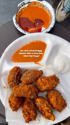 some fried food on a white plate with sauce and ketchup next to it