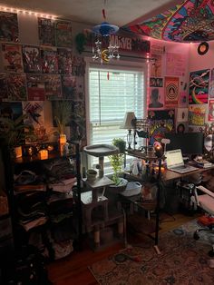 a room filled with lots of clutter and furniture next to a window covered in posters