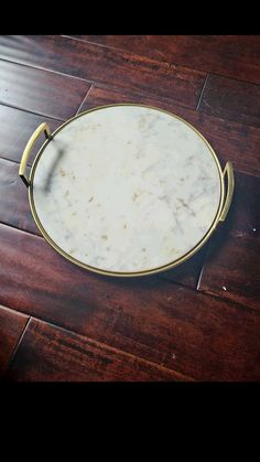 a white marble tray on a wooden floor