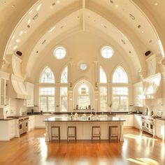 a large kitchen with an arched ceiling and wooden floors