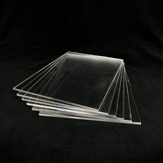 six clear acrylic sheets stacked on top of each other in front of a black background