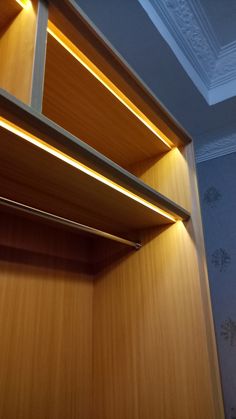 an empty wooden shelf with lights on it