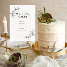 a wedding cake with succulents and greenery on top is sitting on a table