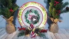 two vases with christmas decorations on them sitting next to a plate that says happy holidays