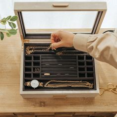 a woman's hand holding onto a jewelry box