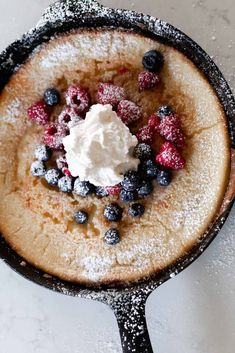 a pancake topped with berries and whipped cream