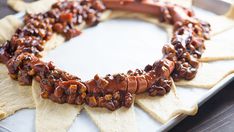 some crackers are arranged in the shape of a wreath on a tray with other snacks