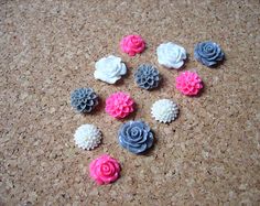 there are many different colored flowers on the corkboard floor, including pink and gray roses