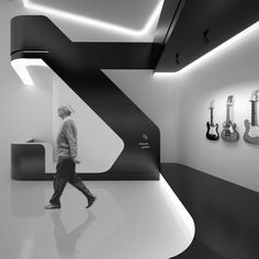 a man is walking through a room with guitars on the wall and in the background