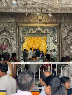 a group of people standing in front of a golden shrine