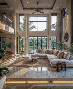 a living room filled with lots of furniture and large windows above the couches in front of them