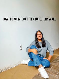 a woman sitting on the floor in front of a wall that says how to ski coat textured drywall