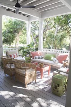 a covered porch with wicker furniture and plants