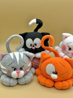 several stuffed animals sitting next to each other on a brown surface with white and black cats