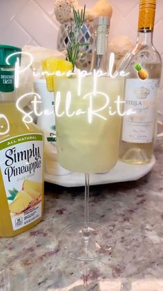 a table topped with glasses and bottles of alcohol next to a plate filled with food