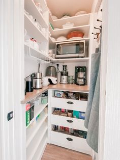 an organized pantry with white cabinets and drawers