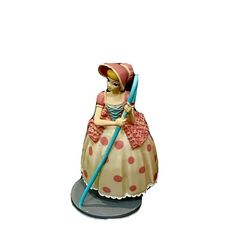 a ceramic figurine is holding a broom