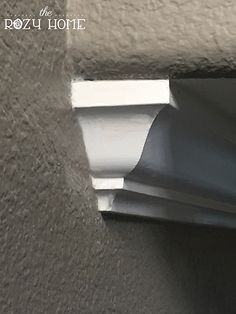 the corner of a gray wall with white trim