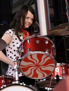 a woman is playing the drums on stage