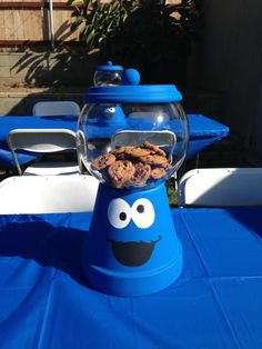 a cookie jar with cookies in it sitting on top of a blue cloth covered table