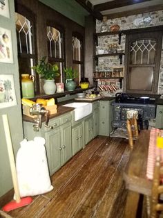 a doll house kitchen with green cabinets and wood flooring is shown in this image